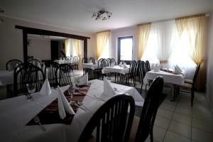 MońkiZajazd Monki的餐厅配有桌椅和白色桌布