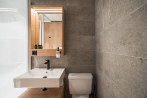圣贝纳迪诺Hotel Brocco & Posta的一间带水槽、卫生间和镜子的浴室