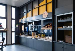 格勒诺布尔B&B HOTEL Grenoble Centre Verlaine的一间有柜台的餐厅,有食物架