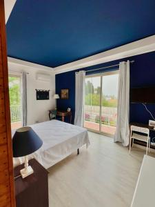 冯塔尼比安奇B&B Villa Dunardi的蓝色的卧室设有床和大窗户