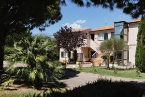 雷卡纳蒂港Villa Chiara Porto Recanati的前面有棕榈树的房子