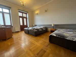热舒夫瓦邦克旅馆的大客房铺有木地板,配有两张床。