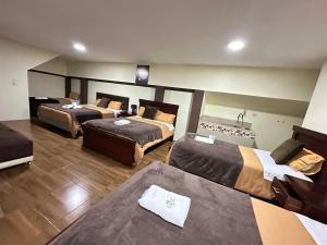 巴尼奥斯Hotel Casa Santa Lucía的酒店客房,设有三张床和一张沙发