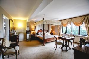 Aherlow阿尔罗小屋酒店的一间卧室配有天蓬床和桌椅