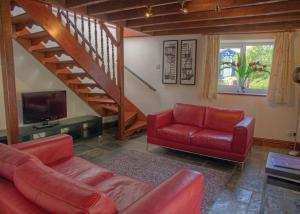 阿博波恩Gwalia Falls的一间带红色沙发的客厅和楼梯
