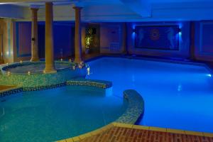 伯恩茅斯Bournemouth West Cliff Hotel的酒店设有一个蓝色灯光的大型游泳池