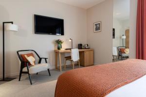 普罗旺斯艾克斯塞尚精品酒店的酒店客房配有一张床、一张书桌和一台电视。