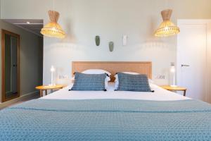 普罗旺斯艾克斯塞尚精品酒店的一间卧室配有一张带蓝色枕头的大床