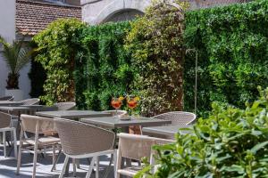 普罗旺斯艾克斯塞尚精品酒店的户外庭院设有桌椅和植物