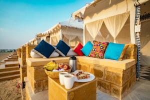 斋沙默尔Desert Heritage Luxury Camp And Resort的一张桌子上装有一碗水果的沙发