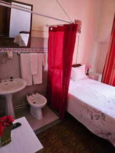 里斯本银色膳宿酒店的一间卧室配有一张带红色窗帘和水槽的床