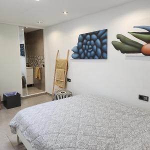 伊科德洛斯维诺斯Casa Salvia Bed and Breakfast的卧室配有一张床,墙上挂有绘画作品