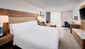 伯灵顿Candlewood Suites Burlington Conference Centre, an IHG Hotel的一间酒店客房,配有一张白色的床和一张书桌