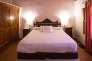 夸科斯德尤斯特亚巴迪亚德乌斯特乡村酒店 的卧室配有一张带白色床单和枕头的大床。