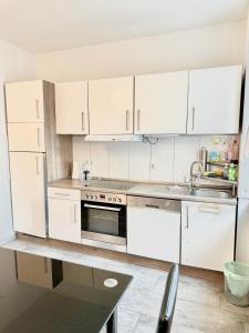 科隆Apartment Mimi Homes Cologne City的厨房配有白色橱柜和水槽