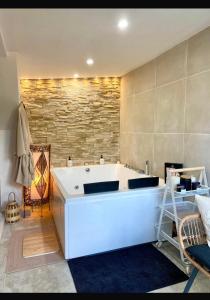 弗朗斯地区特朗布莱Atelier chaleureux - CDG的石墙客房内的浴缸