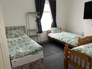 伯恩利Dane Guest House Free Parking Fast WiFi Modern Living的一间卧室设有两张床和窗户。