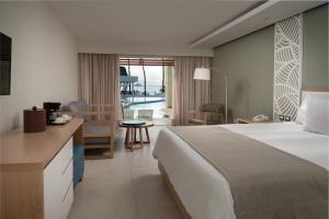 苏莎亚海滨之家海滩及礁石全包度假村的酒店客房配有一张床、一张书桌和一间厨房。