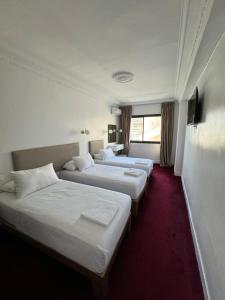 丹吉尔Crystal boulevard的酒店客房设有三张床和窗户。