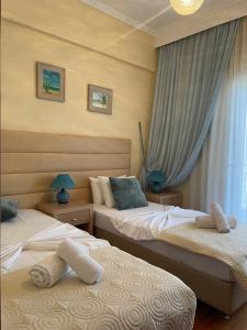 帕拉利亚狄奥尼索Maria Apartments的一间卧室设有两张床和窗户。