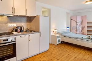 卡尔夫Zentral und nett in Calw的一间厨房,配有白色的橱柜和一张位于客房内的床