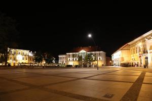 凯尔采Okno Na Rynek -Pokoje Paris -Parking的夜街,有建筑和街灯