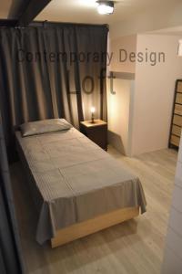 帕多瓦Contemporary Design Loft & Apartment Padova的一间卧室配有一张带窗帘和桌子的床