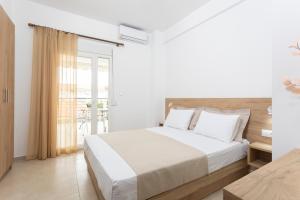 佩科霍里Iasmos - Yiasemi的一间白色卧室,配有床和阳台