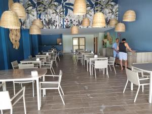 塔曼达雷Flat Eco Resort-Praia dos Carneiros的两人站在带桌椅的餐厅
