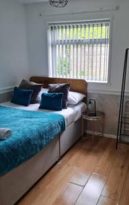 伯明翰Tudors eSuites Budget Studio Apartment的一间卧室配有两张带蓝色枕头的床和窗户。