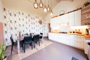 蒙斯Lets Relax - Coté jardin的厨房配有白色橱柜和桌椅