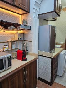 Murshidīyahشقة هادئة بمساحة كبيرة بحي التنعيم بمكة المكرمة غرفة نوم واحدة فقط的厨房配有冰箱和微波炉。