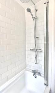 拉什登Stylish 5 Beds House, TV, Garden的浴室设有带淋浴的白色浴缸。