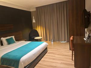 卡萨布兰卡Yto boutique Hotel的酒店客房设有一张大床和一张书桌。