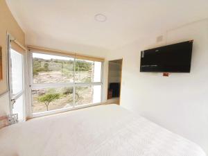 米娜克拉韦罗洛杉安卡雷斯度假村的一间卧室设有一张床和一个大窗户