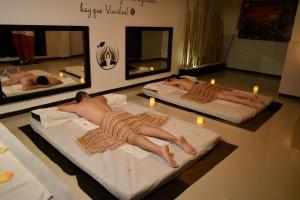 圣罗莎德卡瓦尔Hotel Jade Spa的两个人躺在带蜡烛的房间床上