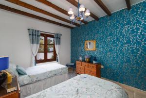 阿索马达Villa Dune的一间卧室设有两张床和蓝色的墙壁