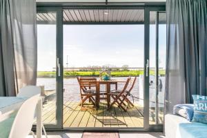 斯滕韦克Unique Houseboat in Steenwijk near Giethoorn的甲板上配有桌椅的用餐室