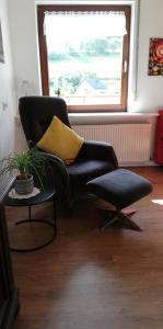 SiebenbachAm Lindenbaum, Ferienwohnung in Siebenbach am Nürburgring的客厅配有黑椅子和黄色枕头
