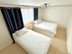 首尔사당 그린나래 스테이的小房间设有两张床和窗户