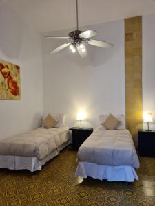 科洛尼亚-德尔萨克拉门托蚕茧酒店的一间卧室配有两张床和吊扇