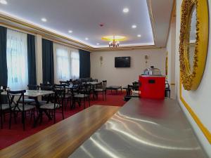 ÇekirgeGlobal Termal Hotel的一间设有桌椅的餐厅,位于一间铺有红地毯的房间内