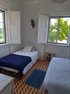 蒙塔吉尔Moradia de férias Casa do Chorão - Montargil的一间卧室设有两张床和两个窗户。
