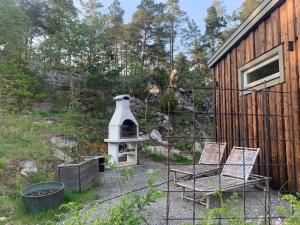 VästerhaningeFullt utrustat Minihus på landet的一个带两把椅子的庭院和一个鸟屋