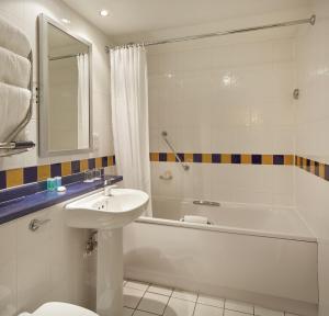 伦敦兰切斯特大门酒店的一间带水槽、浴缸和卫生间的浴室