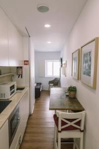 里斯本Casa da Maria Alfama的一间带桌子和微波炉的小厨房