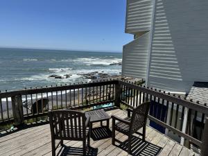 Shelter Cove海滨宾馆的俯瞰大海的甲板上配有两把椅子和一张桌子