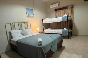 圣多明各Hotel Plaza Kavia的客房设有两张床和一张双层床。