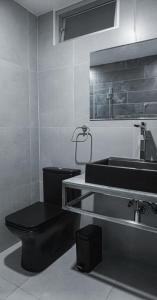廷戈玛丽亚Hotel Rupa Rupa的浴室设有黑色的卫生间和水槽。