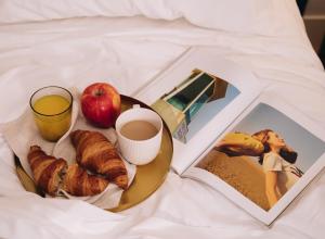 巴塞罗那H La Paloma Boutique的包括苹果、咖啡和书的早餐盘